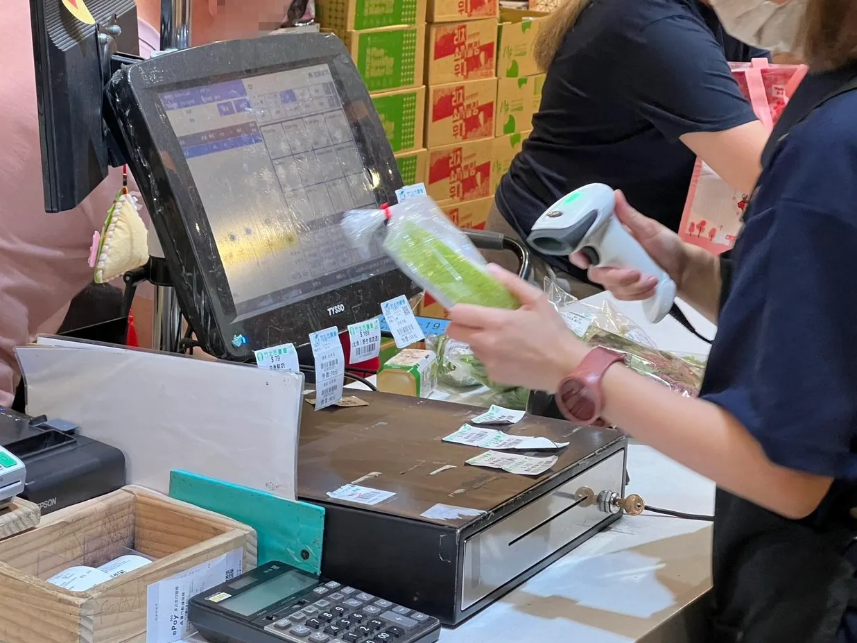 竹北市農會服務人員使用 POS 系統掃描農產品條碼結帳